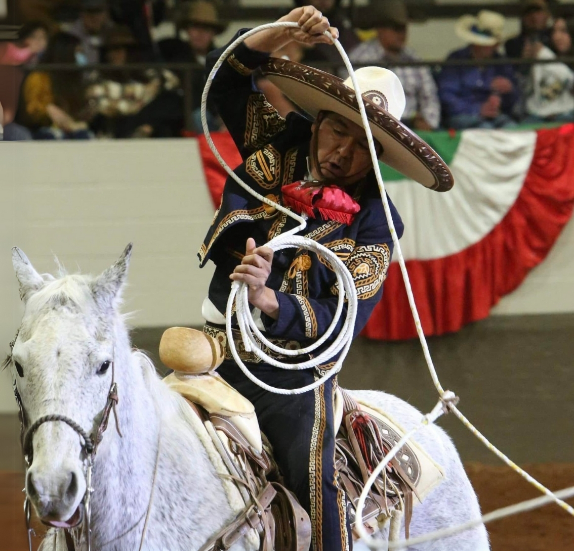 Escamilla riding a white horse with a rope